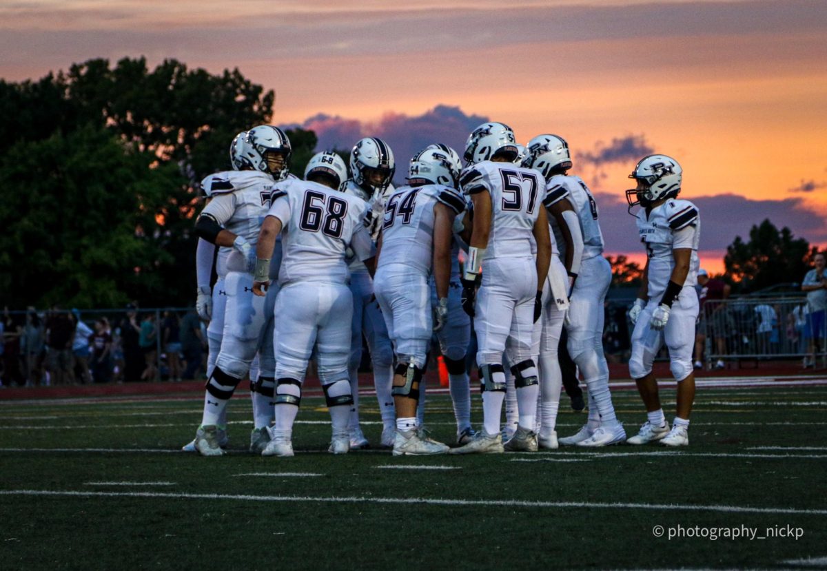 Varsity team huddles up to discuss their next game plan at Lockport, Aug 30.